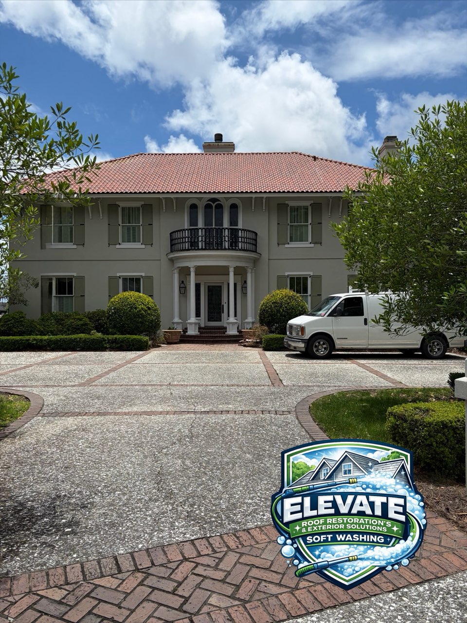 After roof soft washing: the same two-story stucco house, clay tile roof clean and red again, Elevate logo in the corner